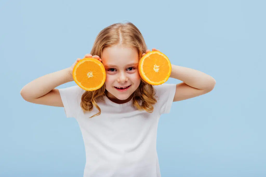 little girl with an orange in her hand